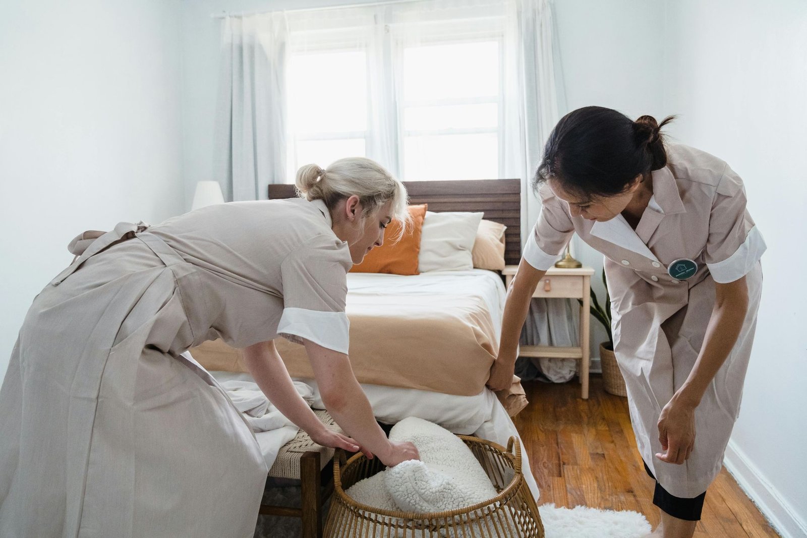 Cleaner preparing fresh white towels in a bright guest bedroom